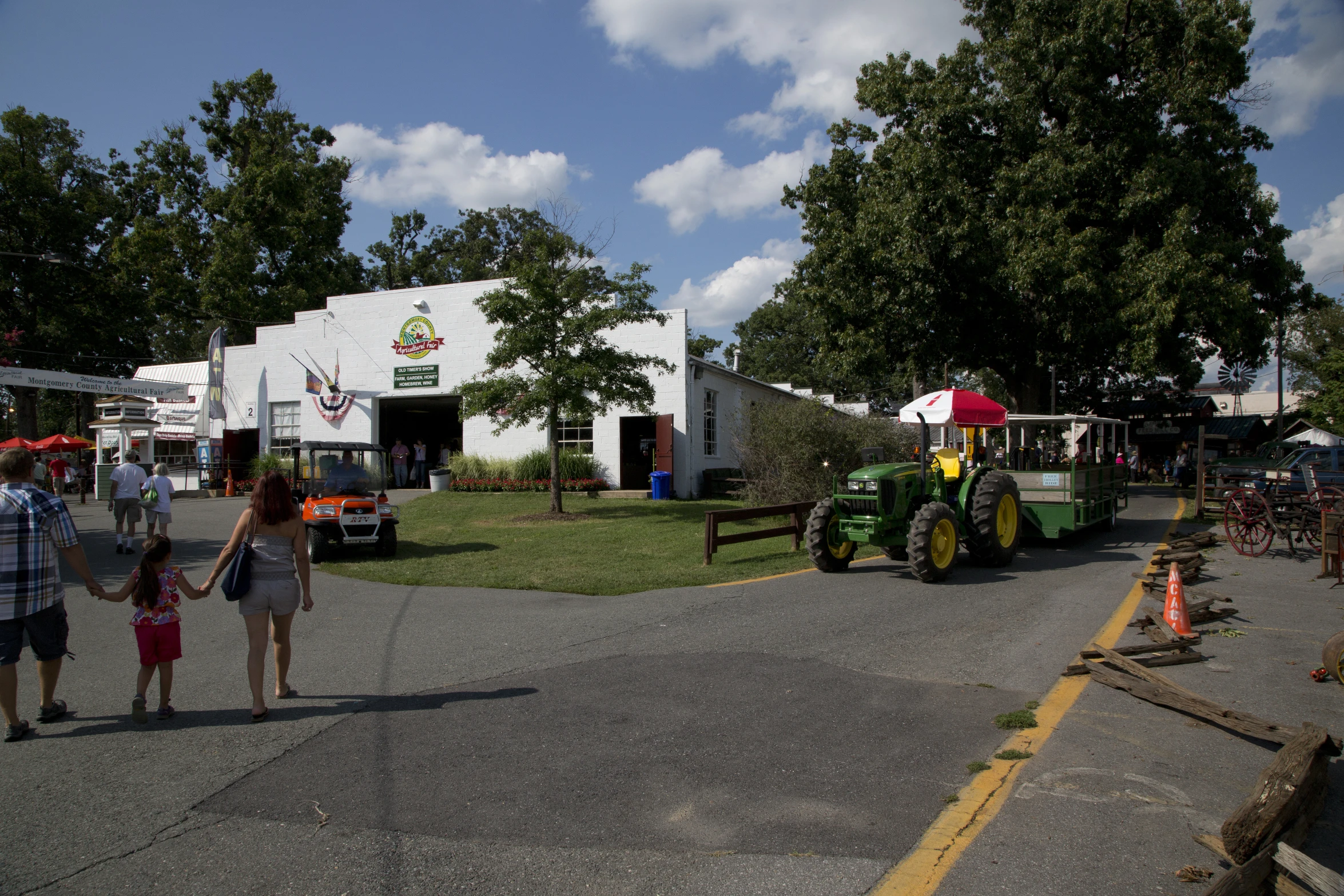 people walking on the road with tractor and trailer parked near them