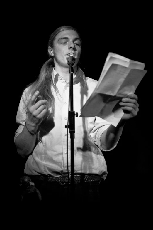 a young woman is reading a newspaper and she is on stage