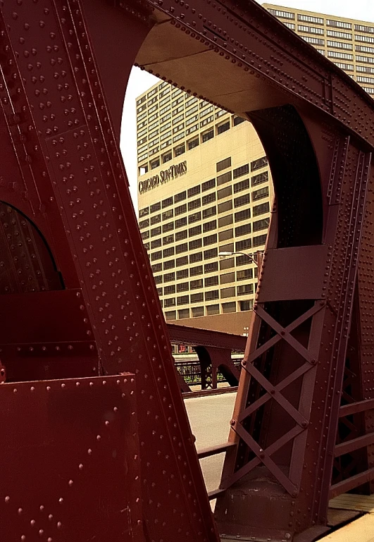 some very big tall buildings by some red and yellow bridges