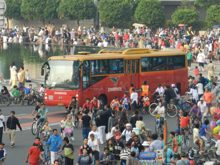 a group of people gathered around a red bus in a city