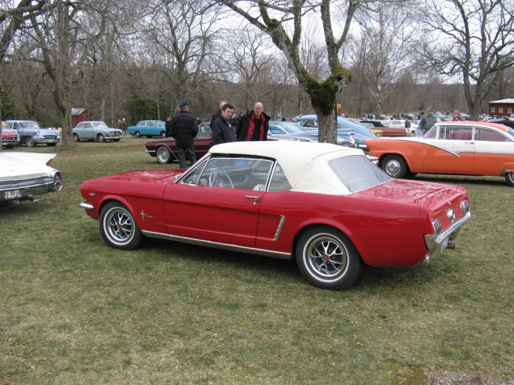 a red and white convertible at a car show
