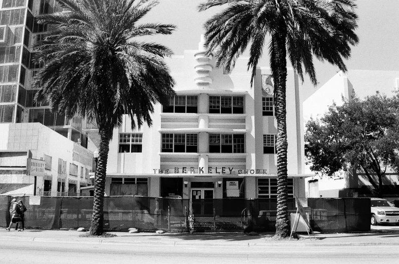 a black and white po shows an old building with palm trees