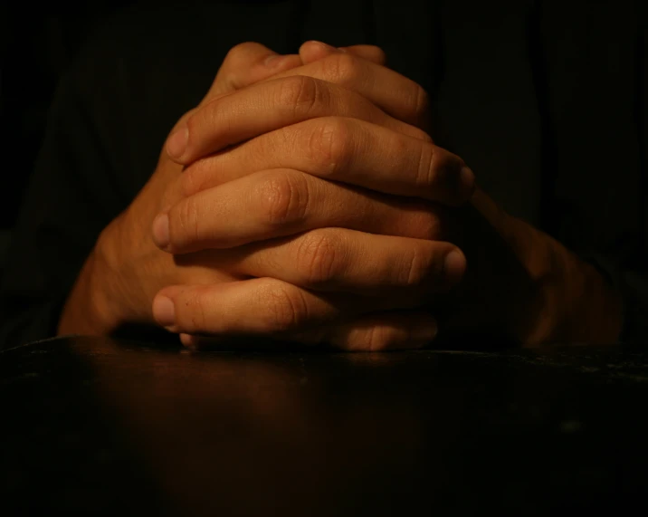 two hands resting against a table