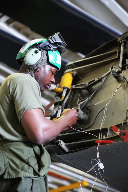 an older black man using a tool on a metal object