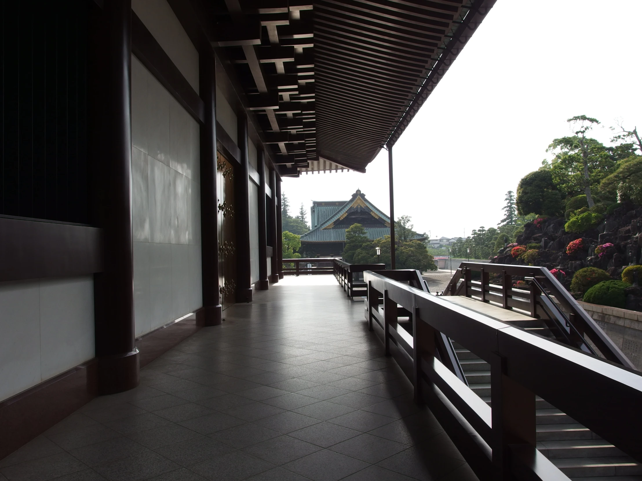 a black and white view of benches along side of a building