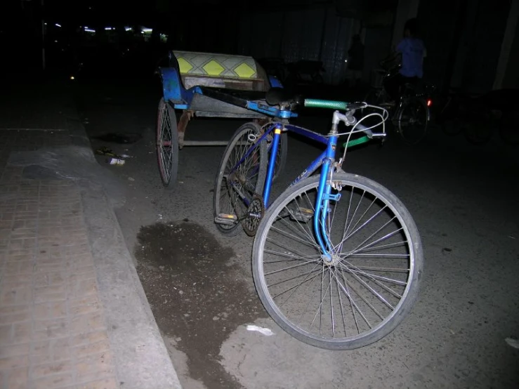 a blue bike in front of a carriage with an empty seat