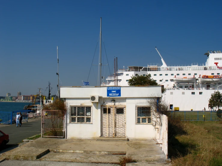 a boat docked at the end of a pier next to the ocean