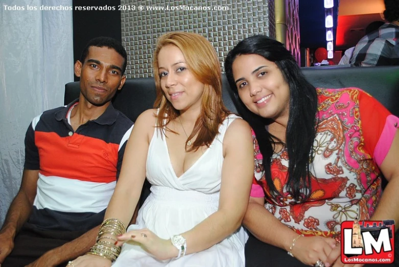 three young people are sitting in the booth smiling