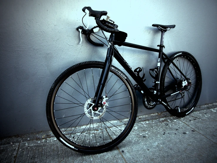 the bike is locked to a wall next to a lamp