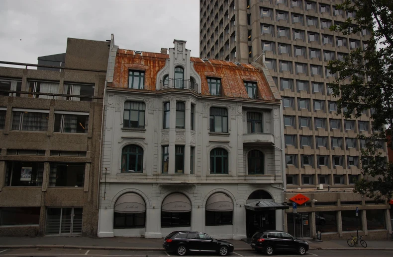 a two story building next to a very tall building