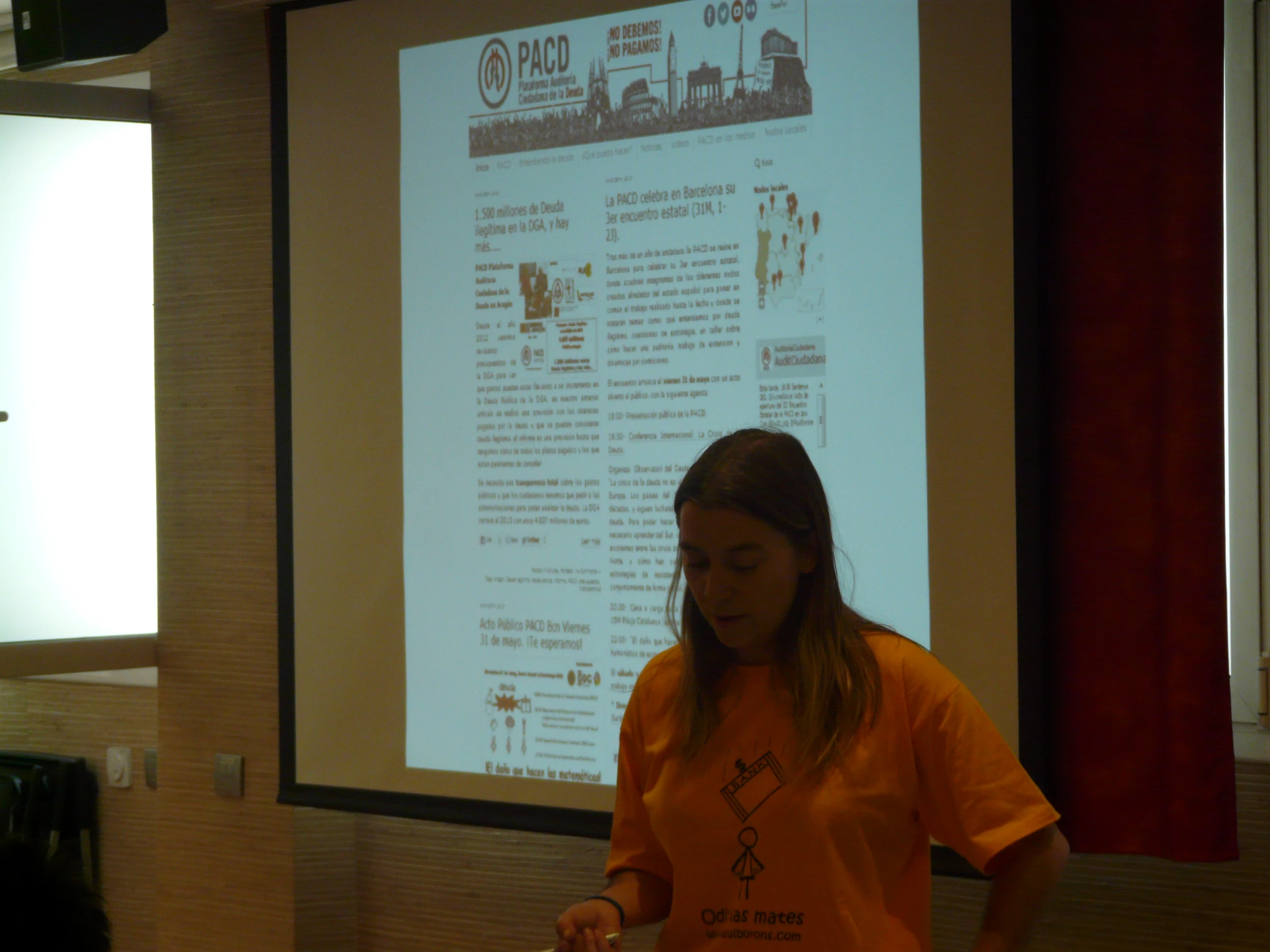 a woman standing in front of a screen with writing on it