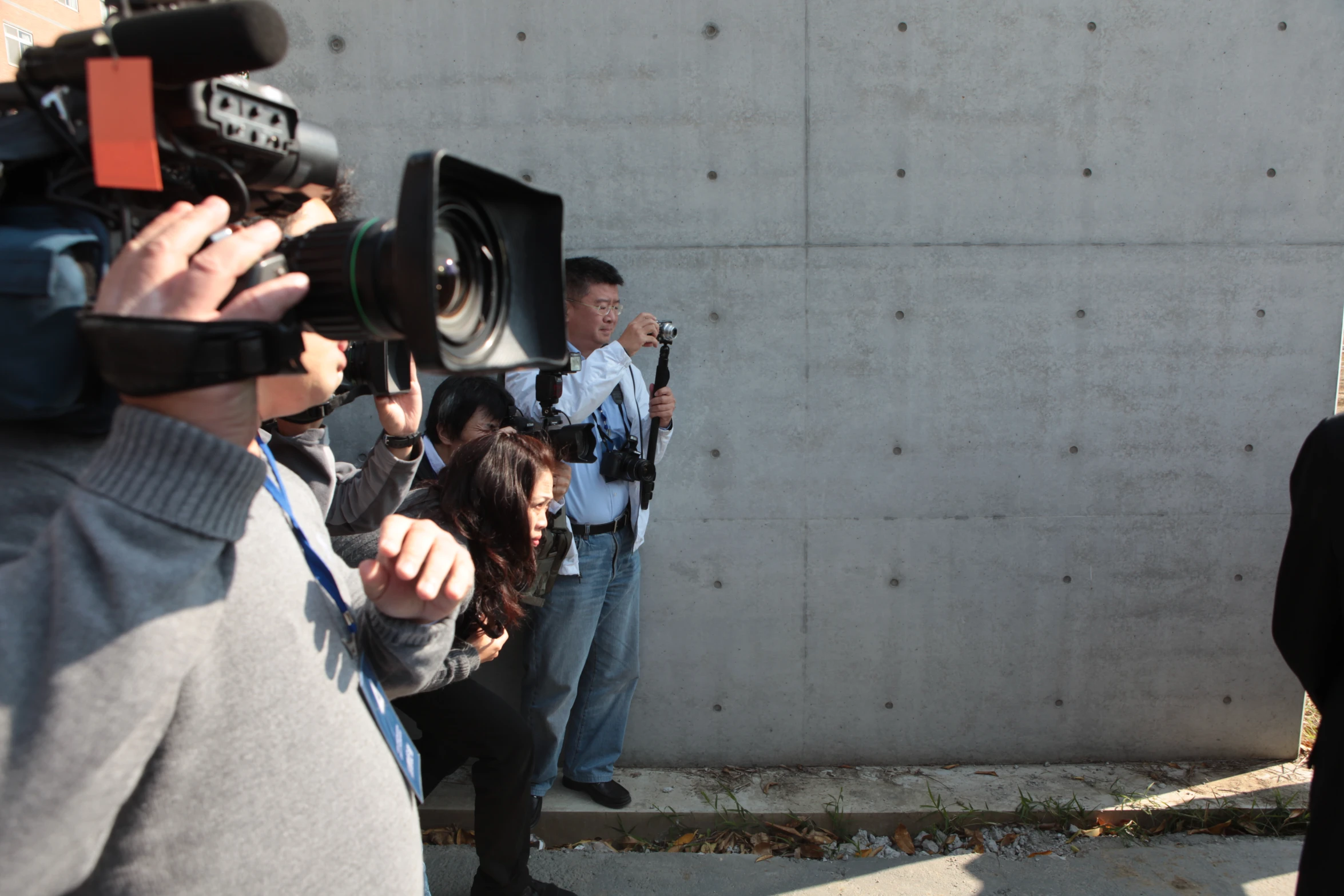 an asian man is holding up his camera and a woman is taking a po