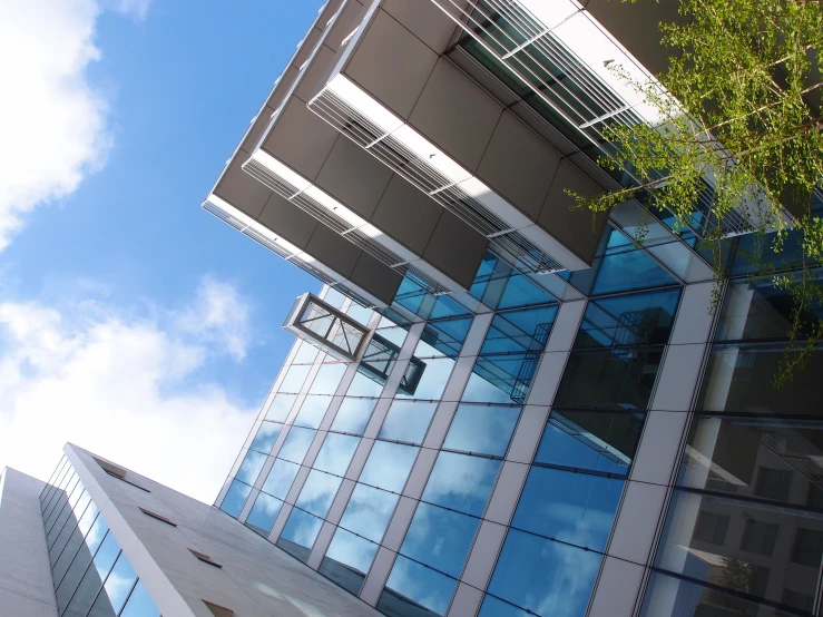 looking up at a tall white building with windows