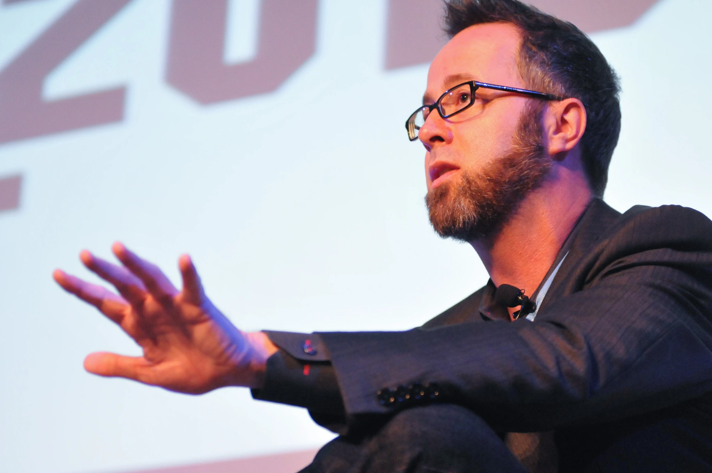 a man with glasses and a beard is giving a speech