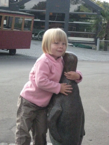 a small child holding onto a large bear