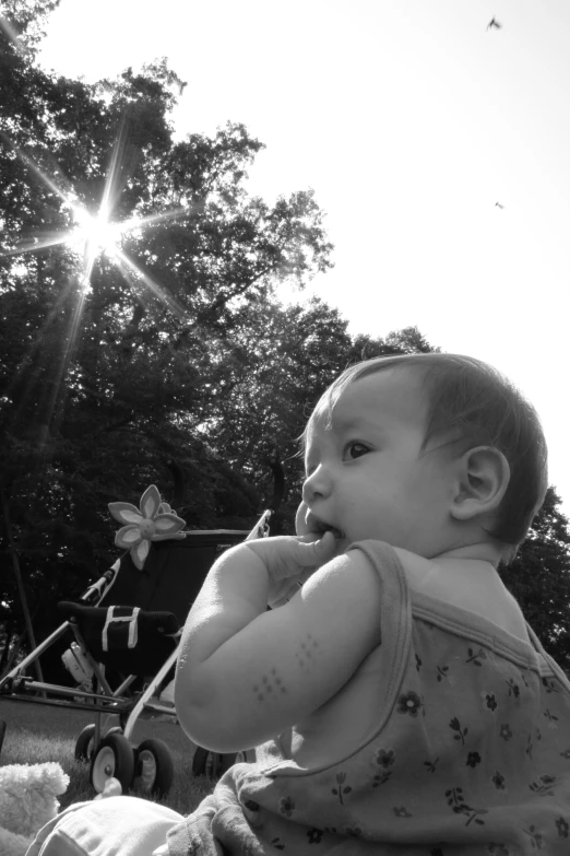 a black and white po of a baby holding onto a piece of soing
