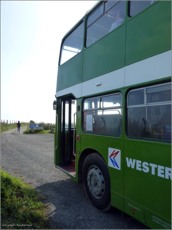 the two story bus is parked on the side of the road