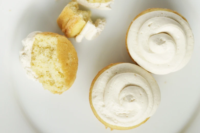 three mini donuts are on a plate with whipped cream