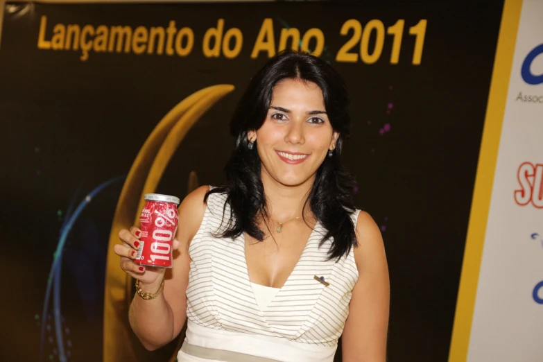 a smiling young lady holding up an energy drink