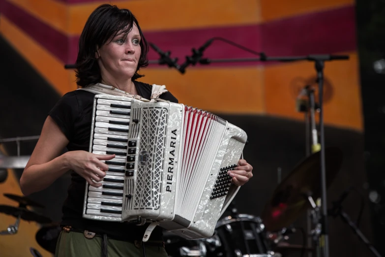 a woman is playing an accordion on stage