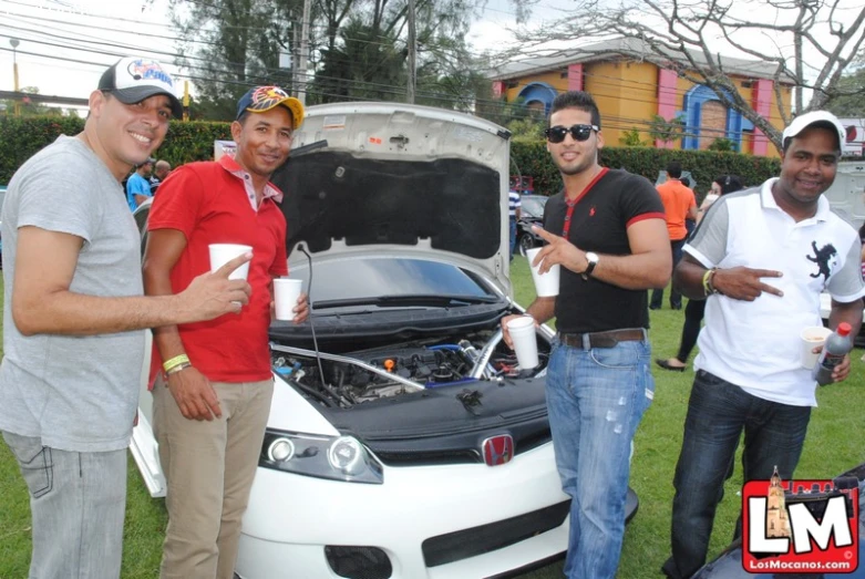 two men standing in front of a car with its hood open