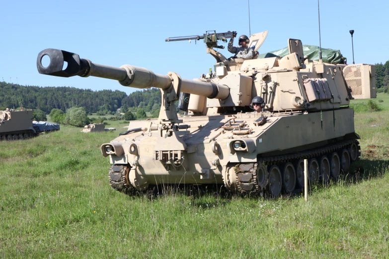 an army type tank in a field with guns on top