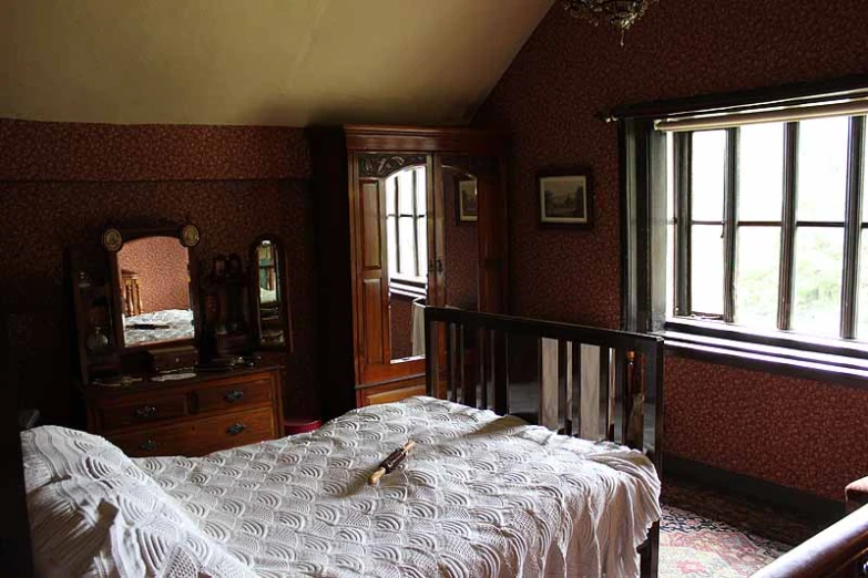 a white bed sitting in a bedroom next to a window