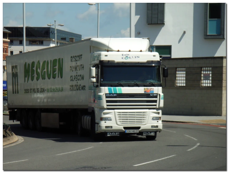 a truck traveling down the street in front of buildings