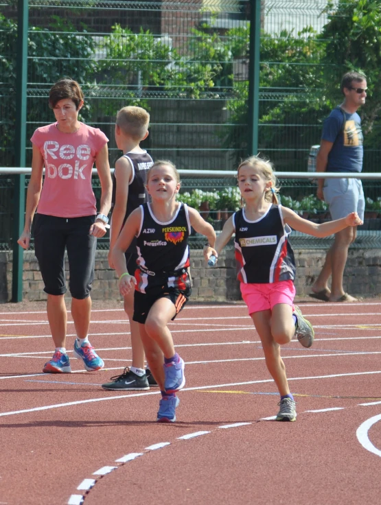 some young children run along on a track