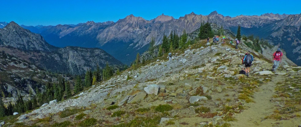 two people walking up the side of a mountain