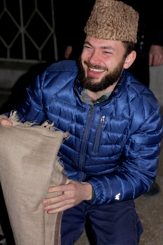 a man holding soing on top of his hand in a bag