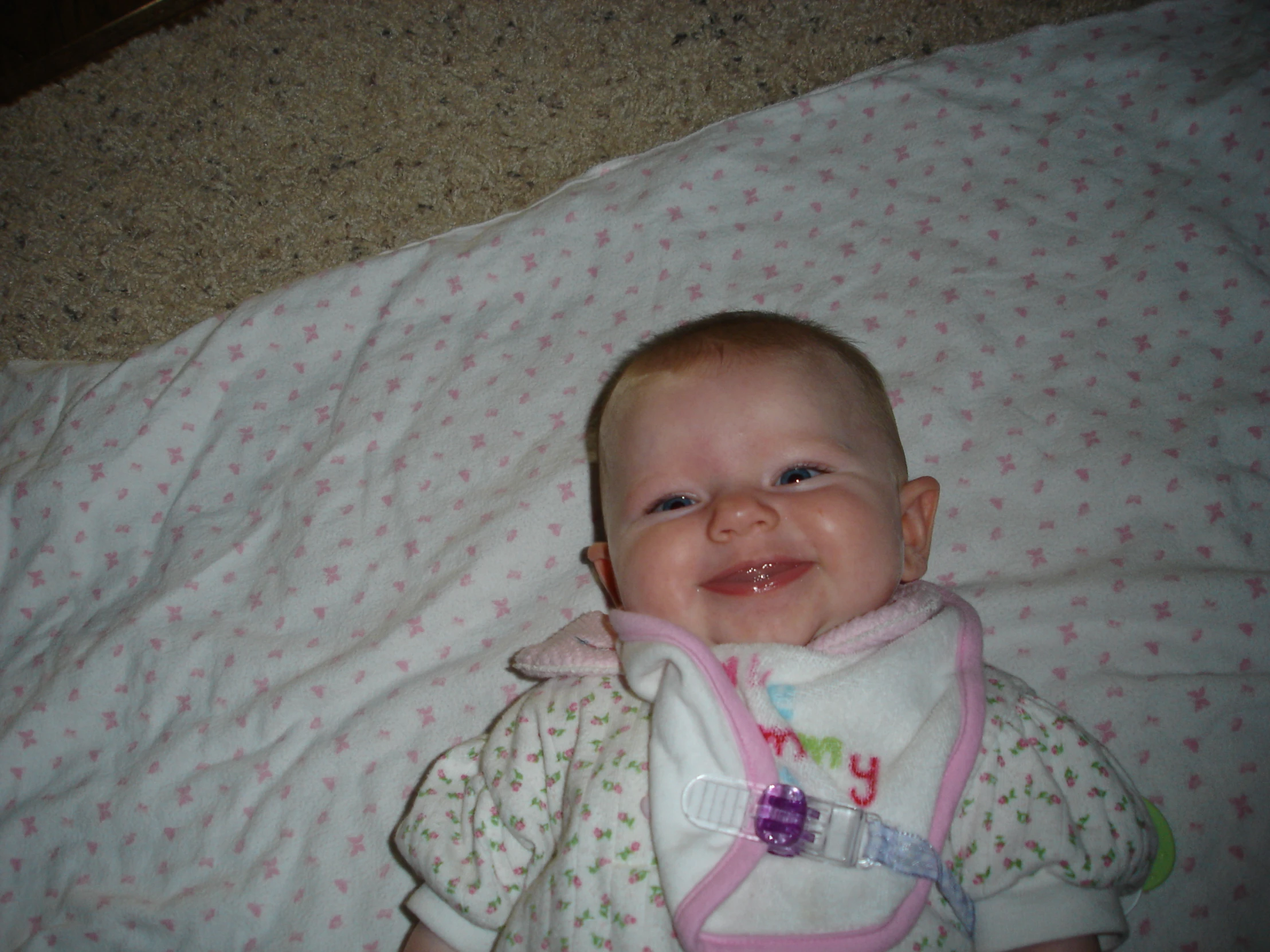 an infant smiling with a pacifier in its mouth