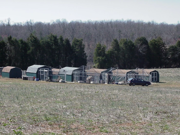 the vehicle is parked in front of the animal cages