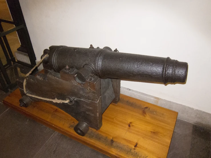 a very large old style telescope sitting on a wooden base