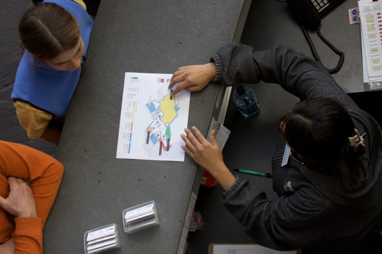 people sit around a table while looking at papers