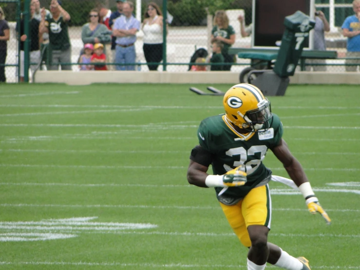 a football player runs with the ball and the other team watches