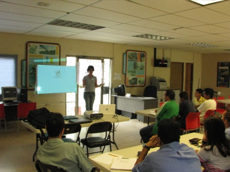 an instructor stands by the chalkboard as a group looks on