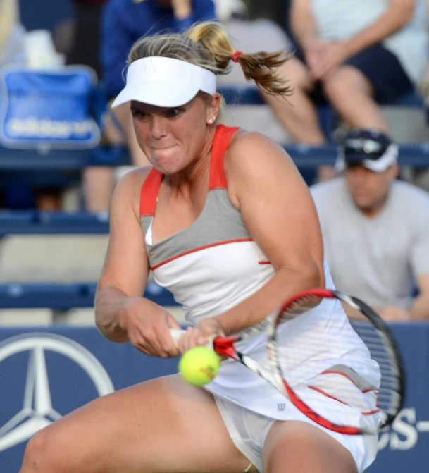 a woman holding a tennis racket is preparing to hit a ball