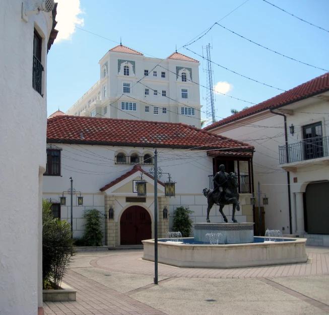 a large white building with a fountain in the courtyard