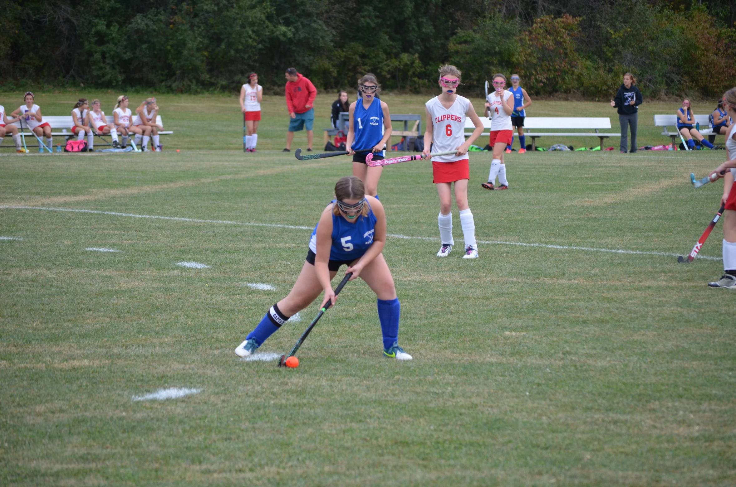 the group of girls are playing a game of field hockey