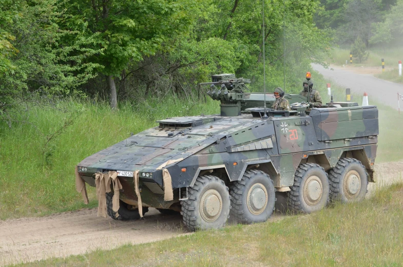 an armored vehicle driving on a dirt road