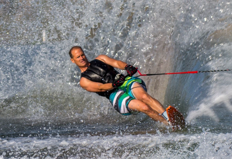 the man is surfing and getting towed by the jet ski