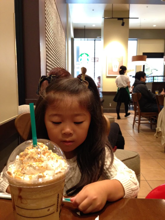 the girl is eating cake in her cup