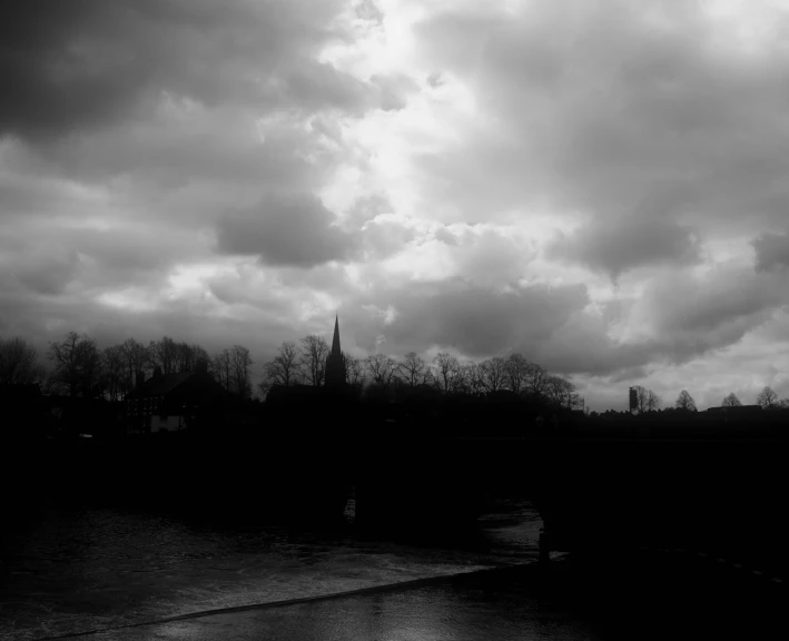 a dark po of clouds, buildings and bridge