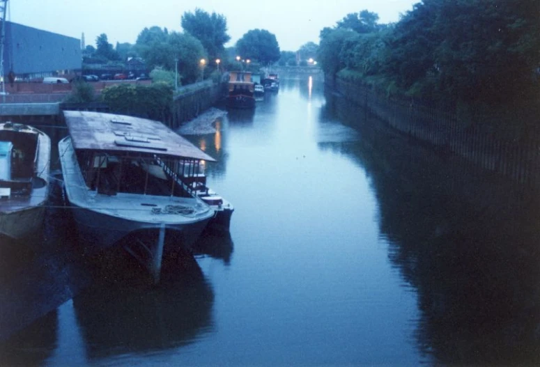 two small boats parked at the dock on a canal