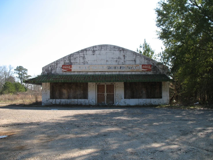 an abandoned building sits in the middle of an empty road