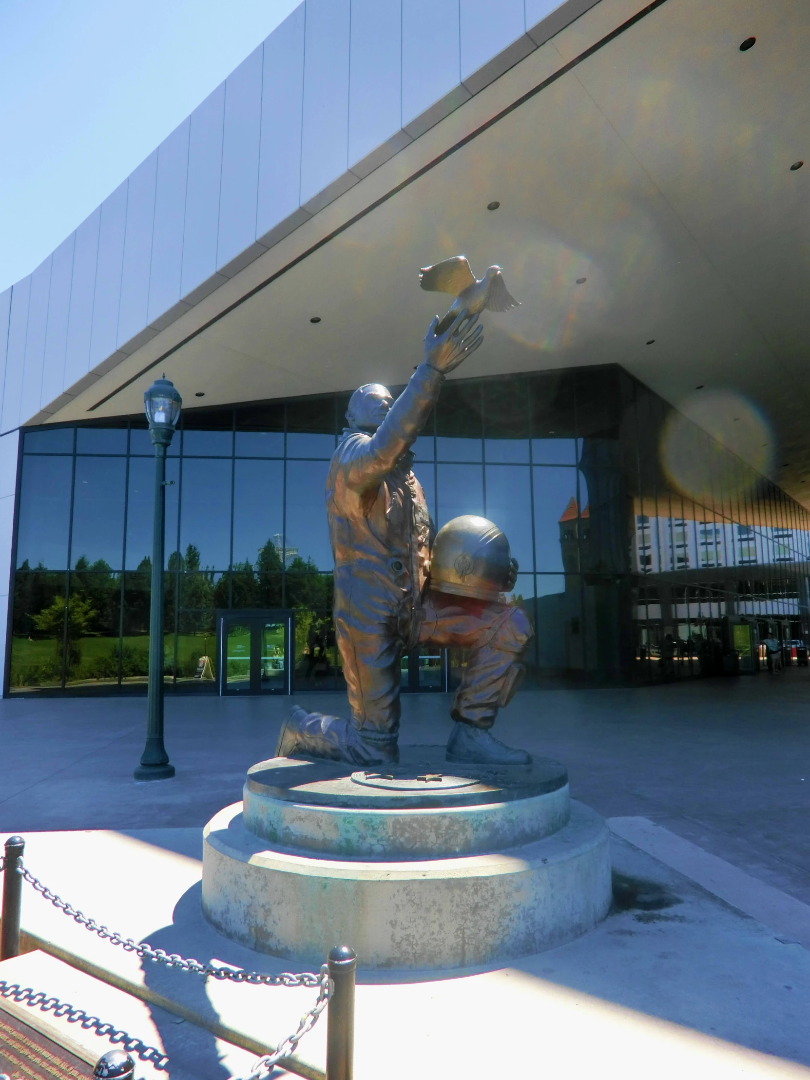 a statue in front of a building with a ball in his hand