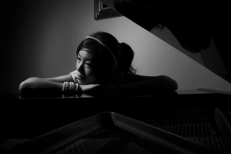 a  wearing pearls sits at the piano