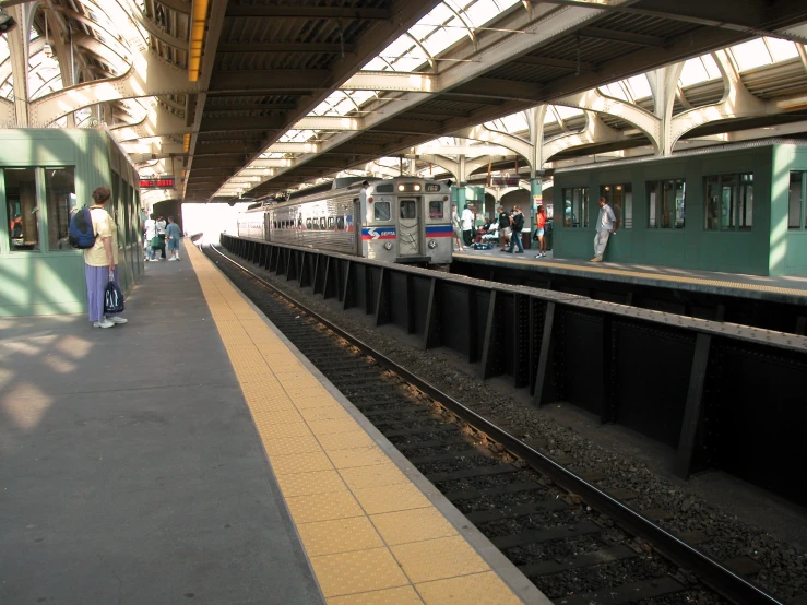 a train station with people walking on the walkway