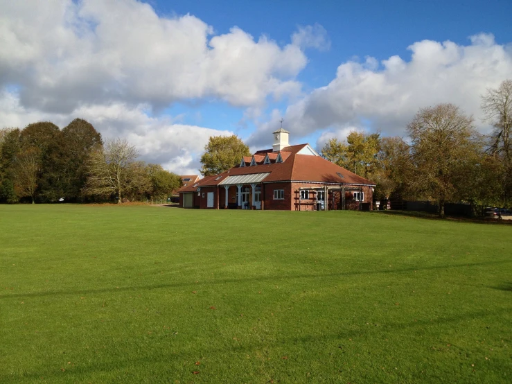 a house in a grassy field and the sky above it